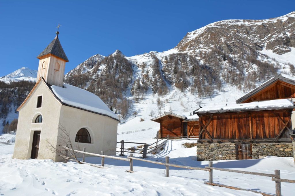 Der Winter auf der Fanealm ist wunderbar. Die Hütten sind weiß angeschneit, auf den Dächern liegt der Schnee.